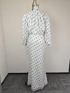Close-up of white and blue polka dot dress featuring delicate lace trim on the hem