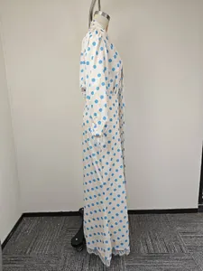 Detail view of lace trim on the cuffs of a white and blue polka dot maxi dress