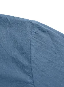 Macro detail of the shoulder seam on a textured blue cotton linen casual shirt