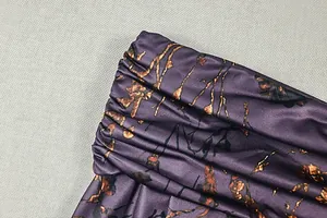 Détail de la taille froncée sur une robe fleurie violette avec texture de tissu