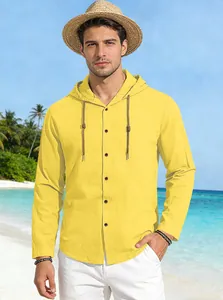 Detail of yellow cotton hooded shirt showing breathable fabric texture on a beach