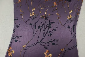 Vue détaillée du tissu floral violet avec imprimés dorés et motifs de branches noires