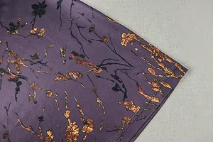 Détail d'une robe en satin violet avec imprimé floral et ourlet à double couture