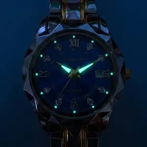 Detail of quartz watch with luminous green hands and diamond markers in dark view
