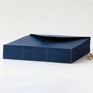 Close-up of stacked premium dark blue pearlescent envelopes with thick paper texture
