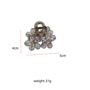 Detail view of a floral hair claw clip with lavender beads and rhinestones