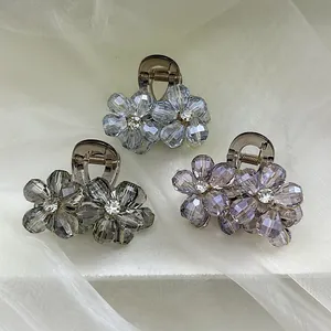 Detailed macro view of small floral hair clips with crystal beads and rhinestones