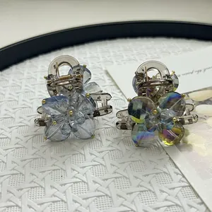 Detailed close-up of acrylic flower hair claws with crystal beads and metal spring