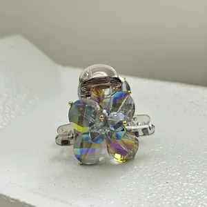 Detail of French style hair claw with iridescent crystal flowers on resin base