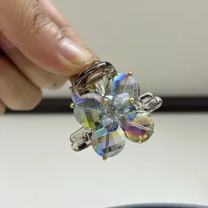 Detailed view of floral hair claw clip featuring iridescent crystals and metallic base