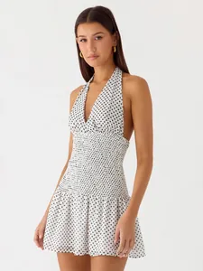 Detailed view of the smocked waist and polka dot pattern on the halter neck dress