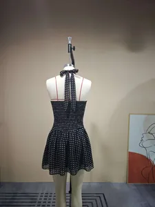 Detailed back view of a polka dot halter dress featuring a large bow tie and smocked waist