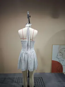 Detailed back view of white polka dot halter dress with smocked waist and tie-back neck