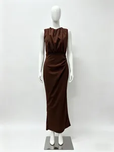 Detail of elegant dark brown sleeveless dress featuring ruched waist and metal accent