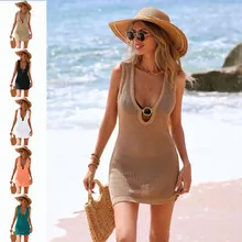 Close-up of crochet hollow out beach cover-up featuring ring detail and tassel trim