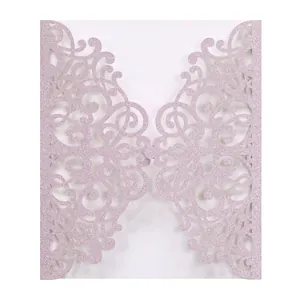 Detail showing laser-cut floral hollow pattern on pink glitter wedding invitation card