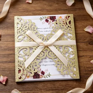 Golden laser-cut wedding invitation with glitter finish and elegant cream bow