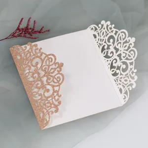 Detail of laser-cut wedding invitation featuring rose gold glitter and ivory hollow patterns
