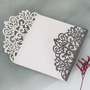 Detail of laser-cut floral pattern with glitter finish on white wedding invitation card