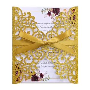 Detail of laser-cut glitter wedding invitation with golden ribbon and floral inner card