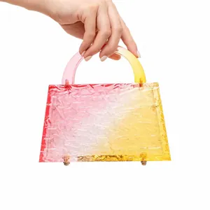 Detail of pink and yellow gradient acrylic evening bag with wavy texture and gold metal feet