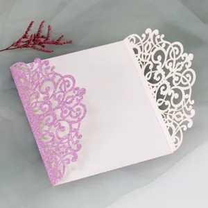 Macro shot of laser-cut purple glitter wedding invitation with intricate vine patterns