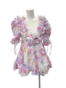Vue détaillée des appliques florales 3D et de l'imprimé fleuri sur une robe dos nu