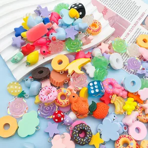 Close-up of colorful resin charms including donuts, fruit, and clouds with metal rings