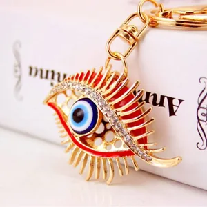 Golden evil eye keychain with sparkling rhinestones and long eyelash details