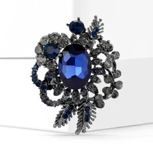Detail of vintage flower brooch with deep blue crystal and grey rhinestones