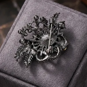 Vintage gunmetal alloy glass brooch with intricate hollow metalwork and safety pin