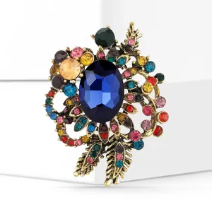 Macro detail of vintage floral brooch with blue gemstone and colorful crystals
