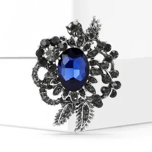 Macro detail of oval blue crystal brooch with vintage silver flower and leaf design