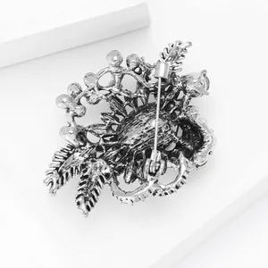 Detailed view of the silver-tone alloy brooch back featuring hollow-out base and safety pin