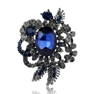 Vintage floral alloy brooch with deep blue crystal and smoky rhinestones on white background