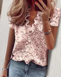 Camicetta rosa a maniche corte con motivo floreale bianco e scollo a V con volant