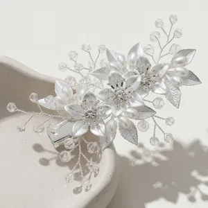 Détail macro d'une pince de mariée faite main avec perles et fleurs en métal argenté