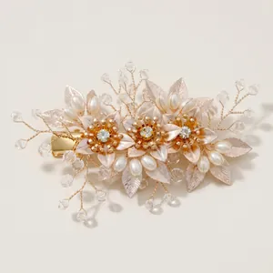 Détail d'une pince à cheveux fleurie dorée avec perles et cristaux artisanaux
