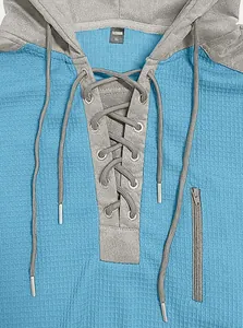 Detailed view of men's waffle knit hoodie with gray drawstring and metal eyelets