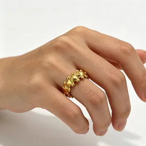 Luxurious gold rivet ring with geometric pyramid pattern and beads on a hand