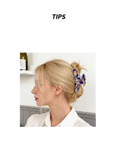 Detail of blue and orange marble acetate hair claw clip styling blonde hair