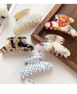 Detailed view of large acetate claw clips in marble, tortoiseshell and vibrant patterns