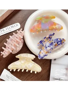 Detail of colorful acetate hair claws in marble and iridescent patterns on a tray