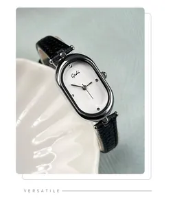 Detail view of Gedi silver oval quartz watch with black leather strap on a shell tray