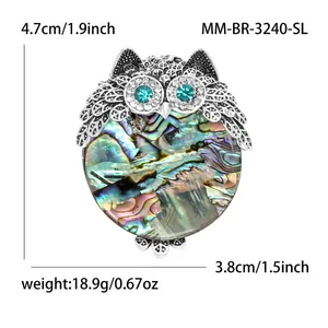 Silver owl brooch with iridescent abalone shell inlay and blue crystal eyes decor