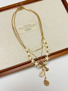 Macro detail of multilayer gold necklace with seashell pendants and starfish beads