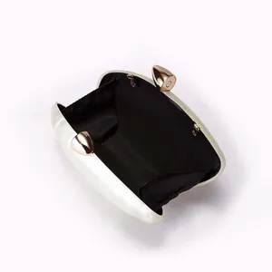 Detail view of acrylic evening clutch featuring marble texture and golden metal hardware
