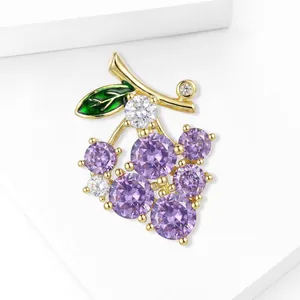 Elegant gold grape brooch featuring purple crystals and a green enamel leaf accessory