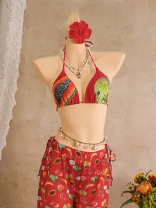 Close-up of tropical fruit print on red halter bikini with matching beach trousers