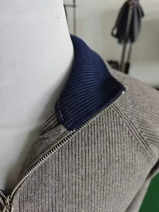 Close-up of contrast knit collar and metallic zipper detail on casual cardigan